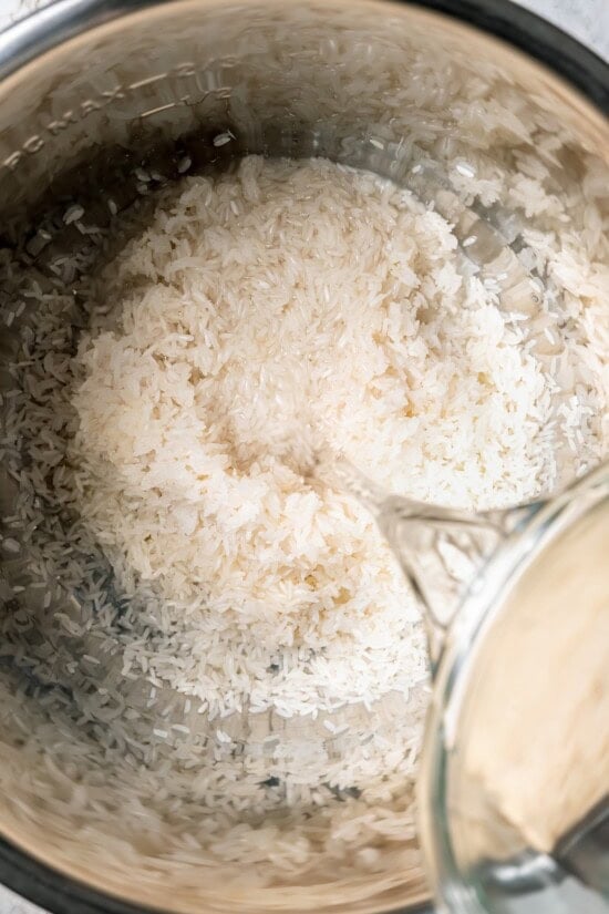 Pouring water into instant pot with rice