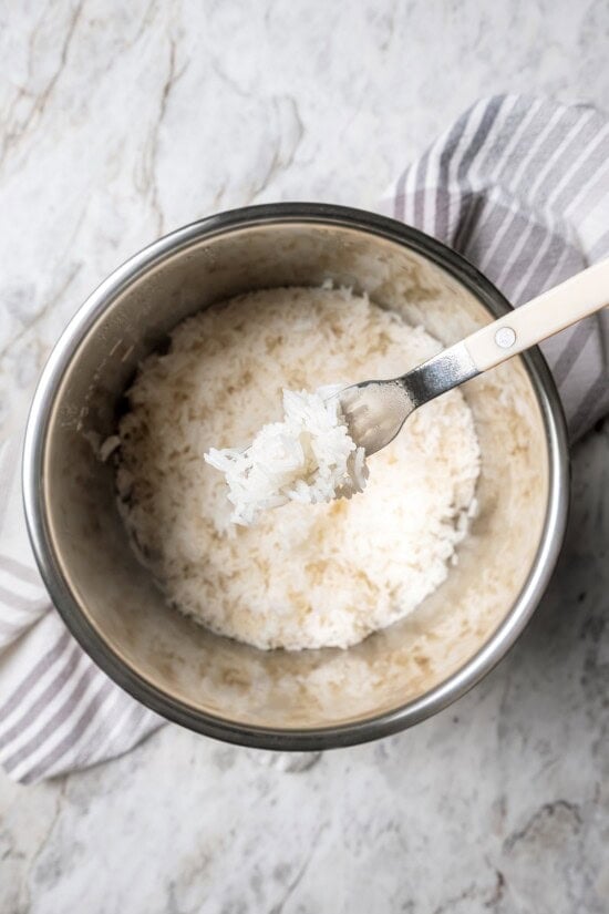 Forkful of jasmine rice held over pot