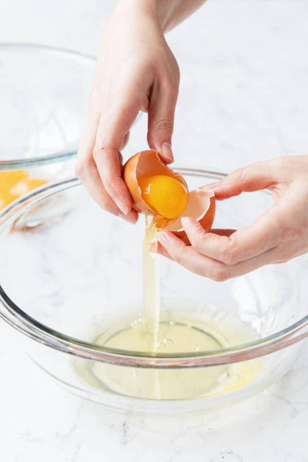 Separating an egg, putting whites in one bowl and yolks in another.