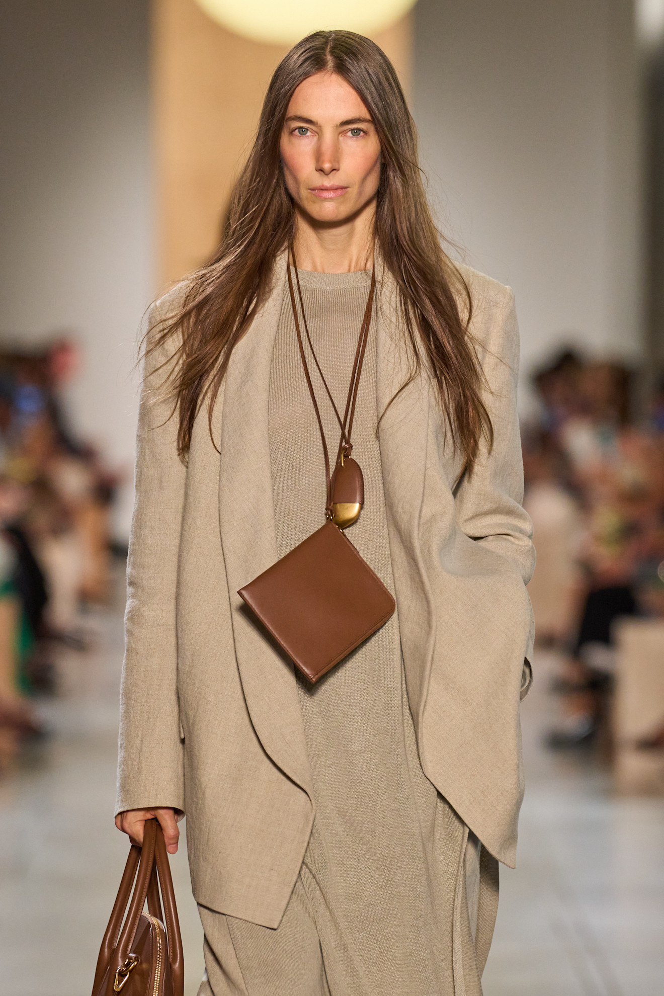 A Michael Kors model wearing a wallet necklace