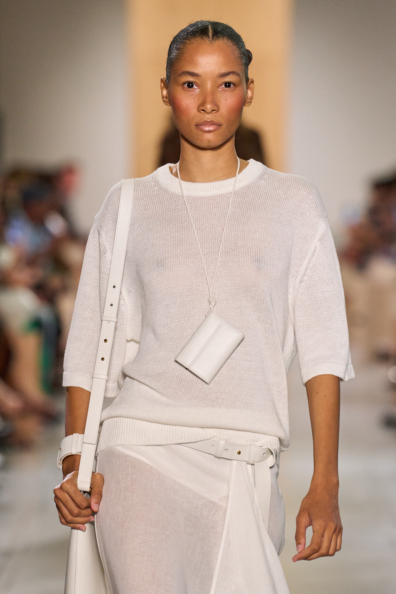 A Michael Kors model wearing a wallet necklace