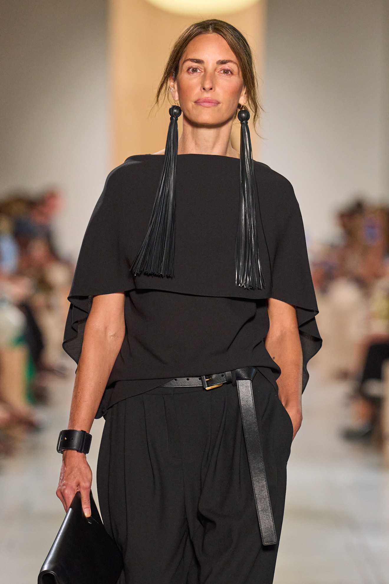 A Michael Kors model wearing black fringe tassel earrings