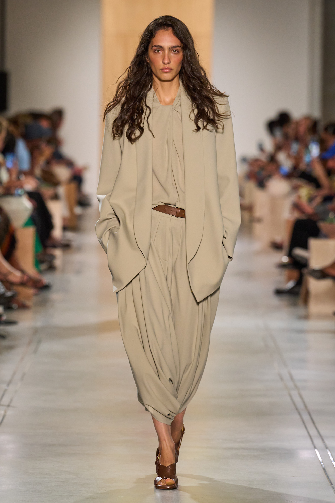 A Michael Kors model wearing a tan, oversized blazer and harem pant