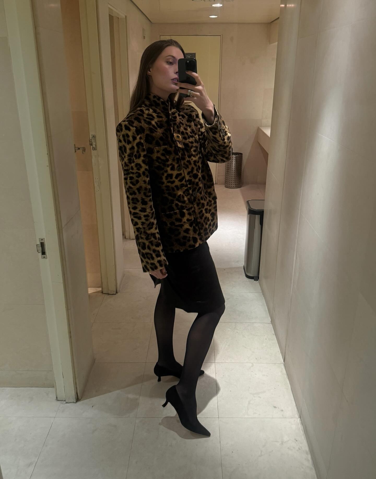 Christie Tyler wearing a skirt outfit idea for 2026, including a leopard-print jacket and black skirt.