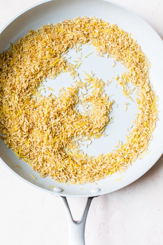 Toasting rice and pasta in a skillet.