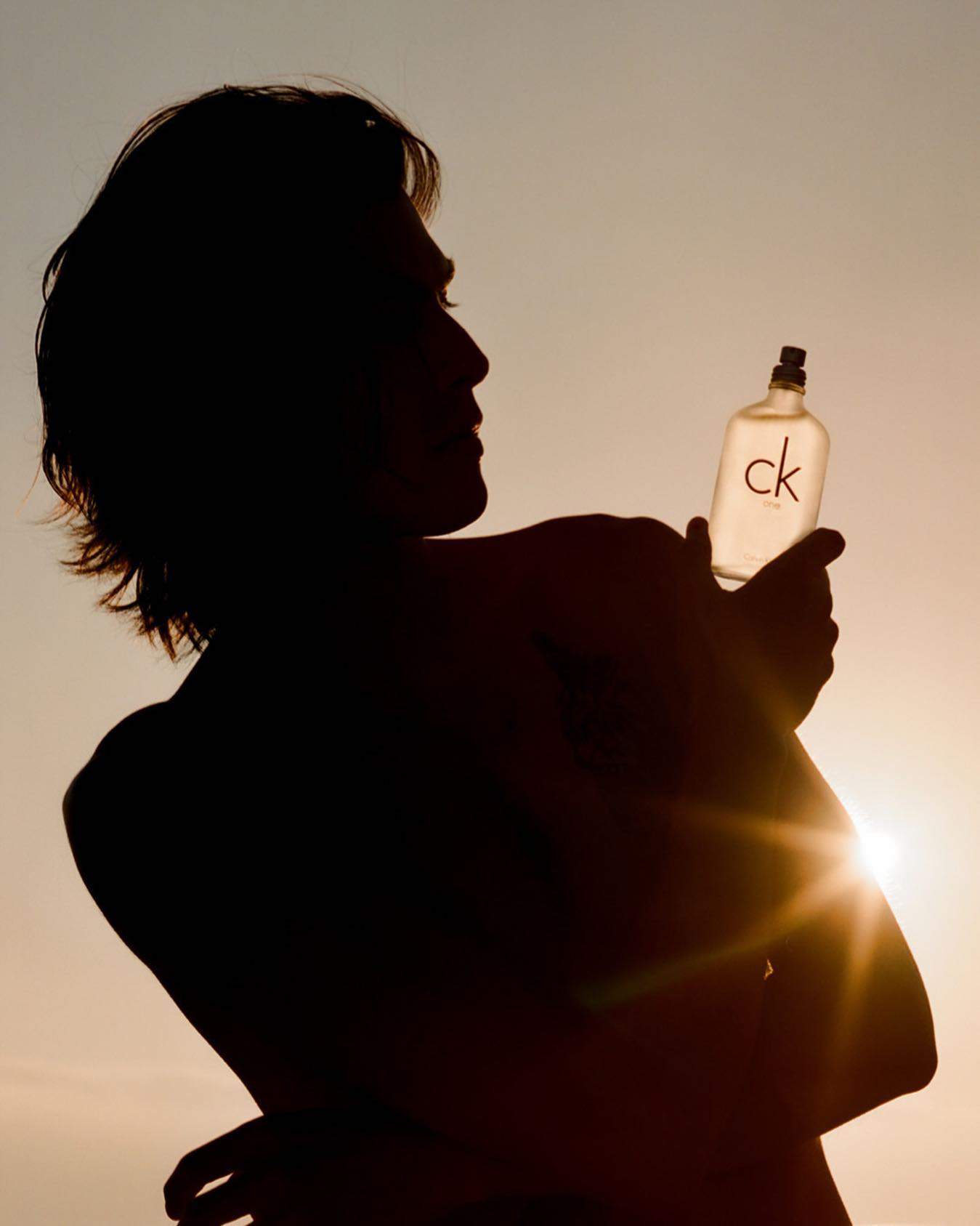 silhouette of a person lifting a bottle of CK one